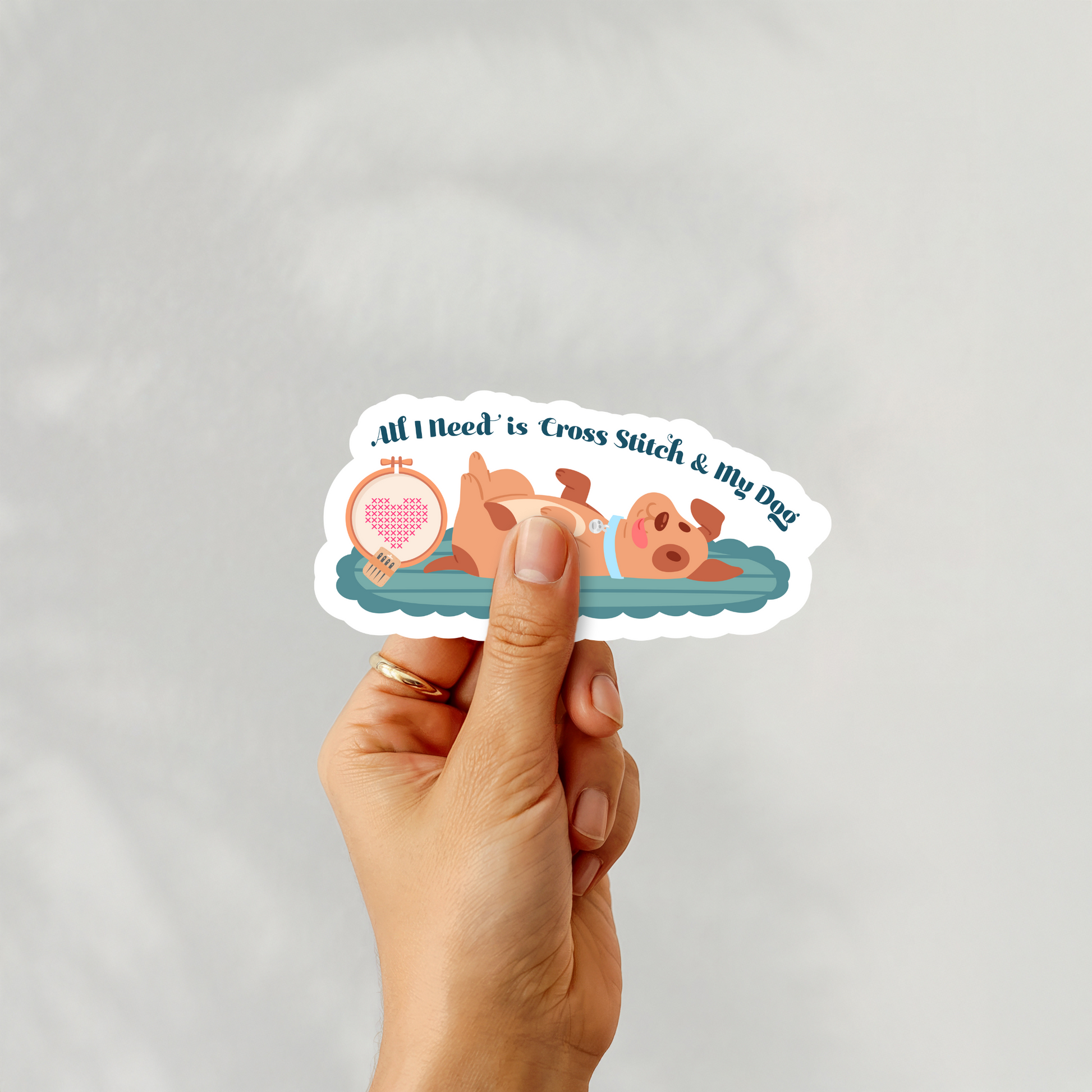 Handheld sticker of “All I Need is Cross Stitch & My Dog”