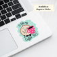 ‘I Like My Coffee 310’ sticker on silver laptop corner, showcasing cross stitch themed design