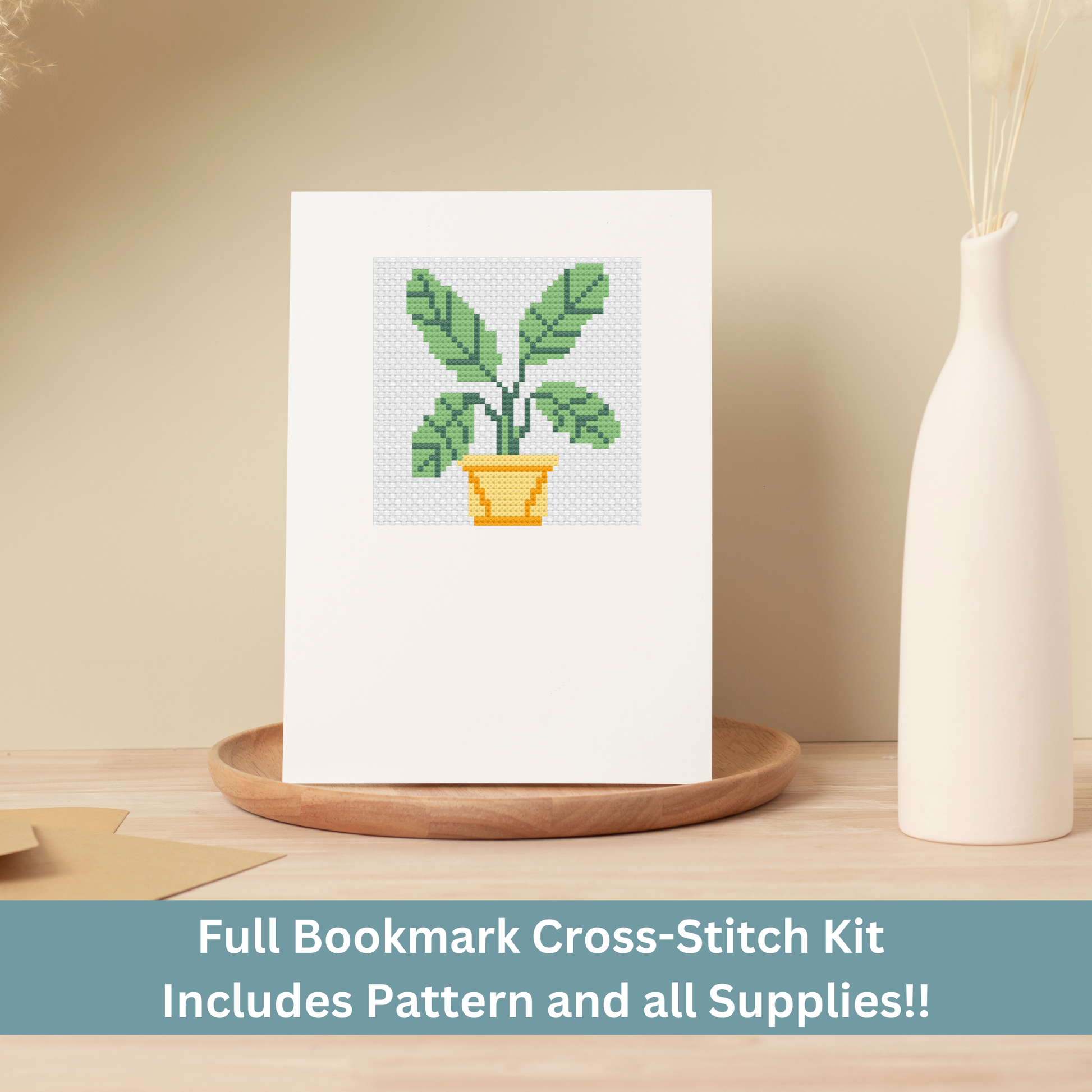 Cross-stitch greeting card featuring a green leafy houseplant in a yellow pot, stitched on Aida cloth.