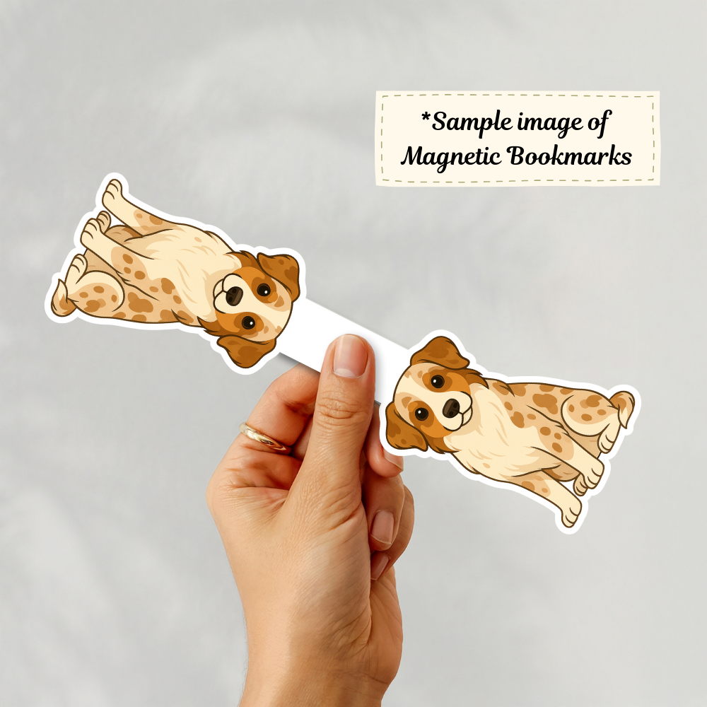 Hand holding a magnetic bookmark with dog illustrations on a gray background